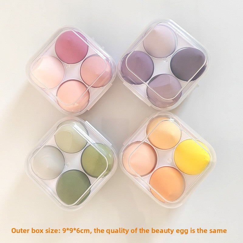 Four small cosmetic boxes with colorful beauty eggs on a light background