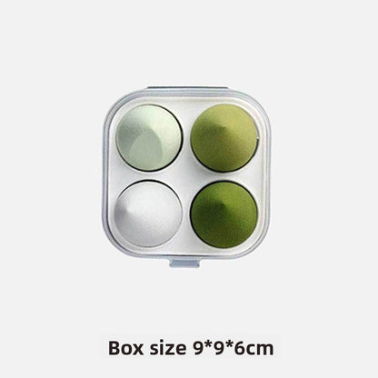 Four-section mold with green and silver balls on a white background