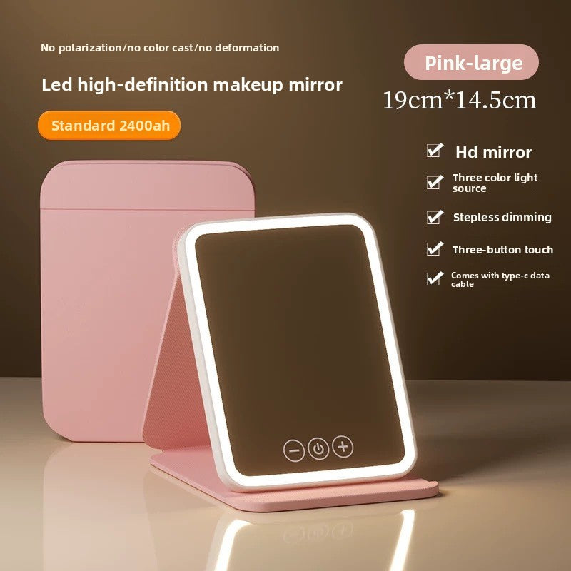 Pink LED makeup mirror with stand on a reflective surface, against a dark background.