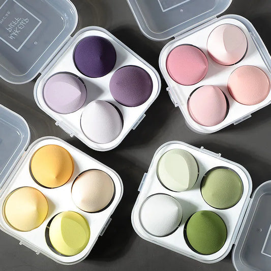 Set of colorful makeup sponges in a compact case on a dark surface.